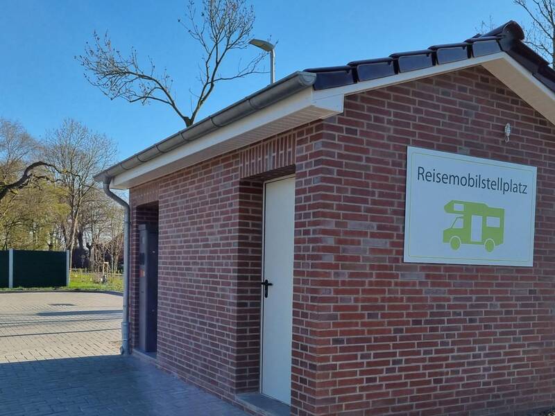 Technikgebäude mit Eingangsschild zum Berumerfehner Reisemobilstellplatz